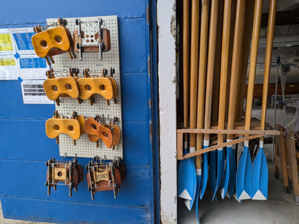 Bootshauswand mit hölzernen Riemen und Rollsitzen