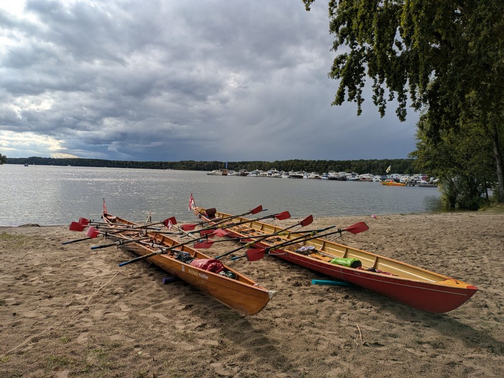 Ans Ufer gezogene Boote vor Unwetterfront